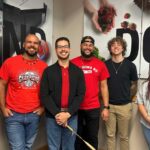 NC State Native American Alumni Network members gather for a photo in front of a Wolfpack 