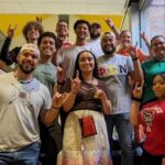 NC State Native American Alumni Network members show their school spirit by tossing up the Wolfie sign for a group photo.