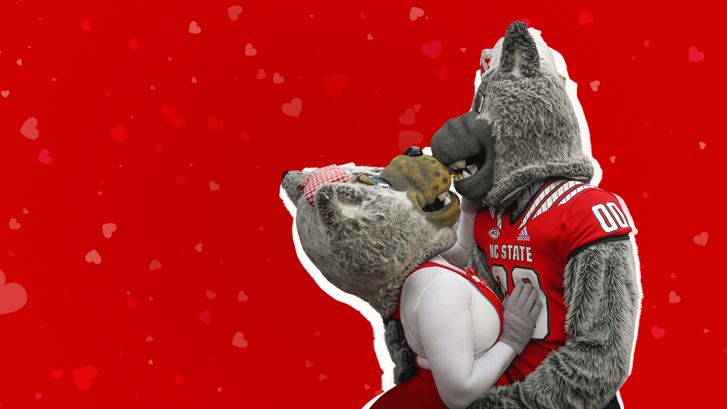 Mr. Wuf and Ms. Wuf kissing in front of a red background of hearts.