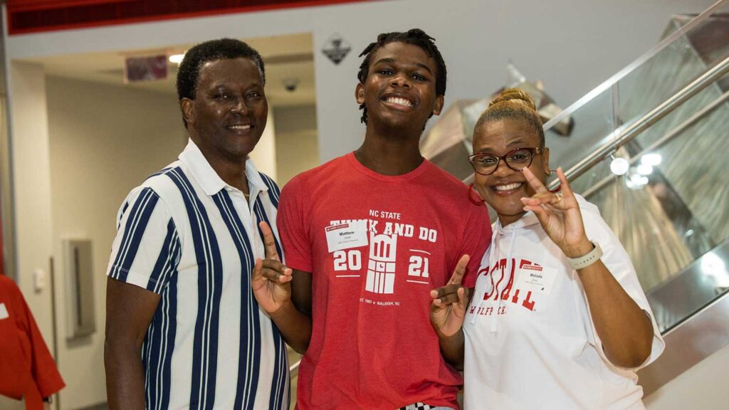 Proud family members smile with a young incoming NC State student at the